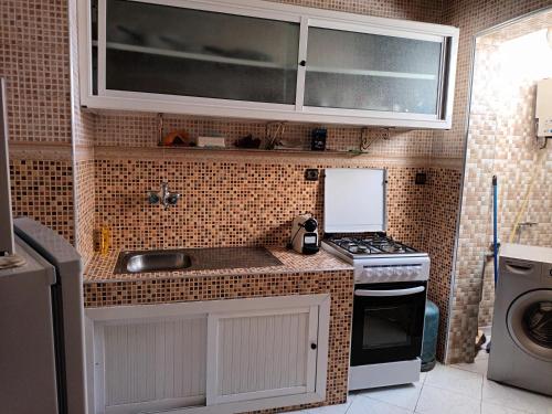 阿加迪尔Grand T3 meublé et propre的一间带水槽和炉灶的小厨房