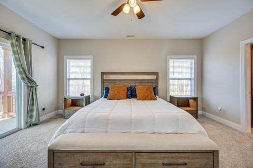 Roaring River Retreat with Home Gym and Fireplace!的一间卧室设有一张大床和两个窗户。