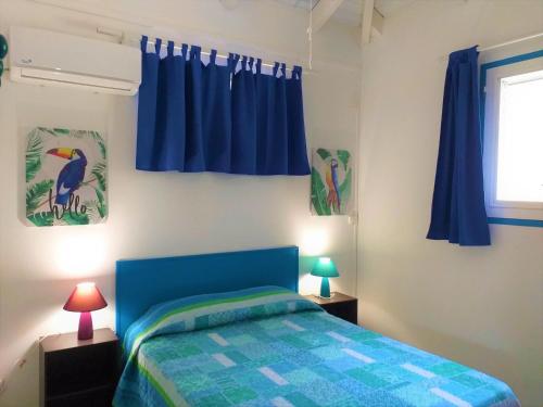 勒迪亚芒Résidence les Océanides的一间卧室配有蓝色的床和蓝色窗帘