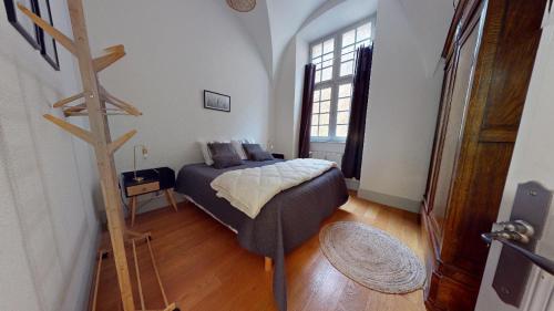 多勒Le Prieuré的一间卧室配有一张床,铺有木地板