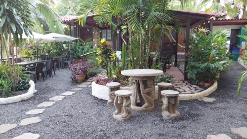 圣卡塔利娜岛Hotel y Restaurante Mama Ines的一座花园,在一座建筑前设有桌子和凳子