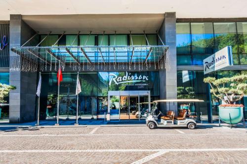 伊斯坦布尔Radisson Residences Vadistanbul的停在大楼前的高尔夫球车