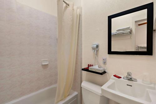 旧金山Mithila San Francisco - SureStay Collection by Best Western的浴室配有盥洗盆和带镜子的淋浴