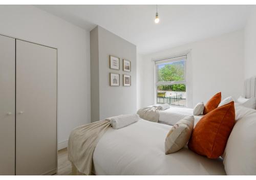 伦敦Serenity, Scenery, Shopping, & Sports的一间白色卧室,配有两张床和窗户