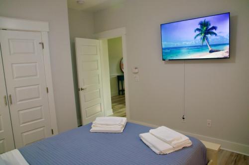 巴拿马城海滩Peaceful Shores Retreat的一间设有床铺的客房,墙上配有电视