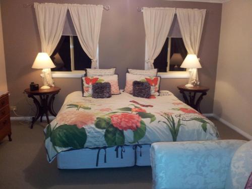Margate水景花园住宿加早餐旅馆的一间卧室配有一张带花卉床罩的床和两个窗户