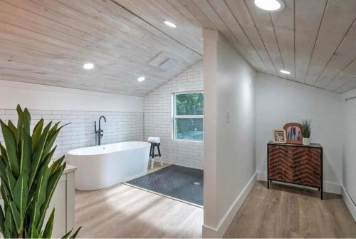 塔尔萨Midtown Masterpiece Whot Tub, Pets Welcome!的一间带白色浴缸和植物的浴室