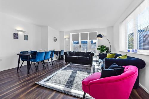 伦敦Charming and Modern 2 BR Flat的客厅配有粉红色的沙发和蓝色的椅子
