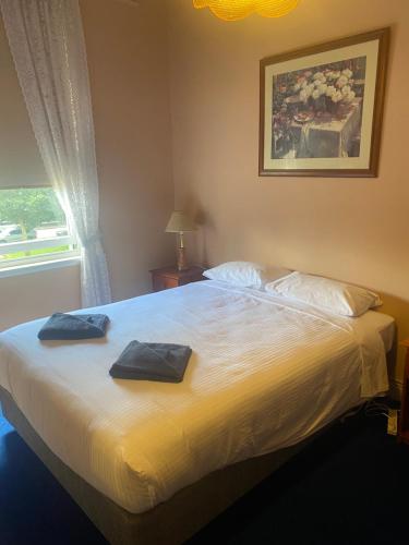 坎伯当Commercial Hotel Camperdown的一间卧室配有一张大床和两条毛巾