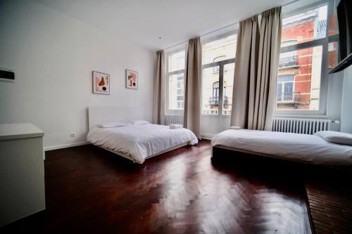 布鲁塞尔Smart Appart - Bossaerts的一间卧室设有两张床和两个窗户。