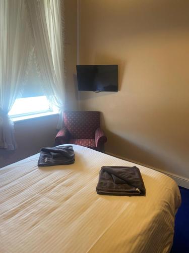 坎伯当Commercial Hotel Camperdown的酒店客房,配有一张带两个袋子的床
