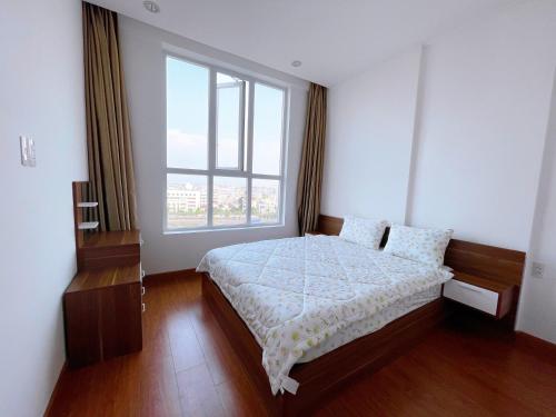 龙川市Lá Homestay Apartment的一间卧室设有一张大床和大窗户
