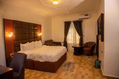 OnitshaAbada Luxury Hotel and Suites的一间卧室设有一张床和一间客厅。
