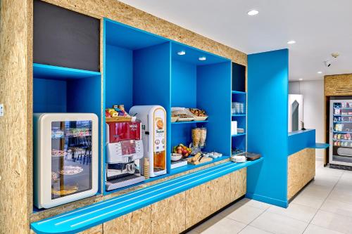 舍诺夫Kyriad Direct Dijon Sud - Chenove的一间拥有蓝色墙壁和冰箱的商店