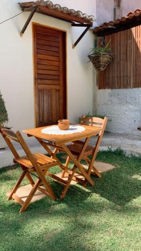 弗雷谢拉斯Suíte Nativa - Flecheiras的木屋前的一张木餐桌和两把椅子