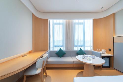 胶州全季酒店(胶州胶东机场李王路店)的客厅配有沙发和桌子