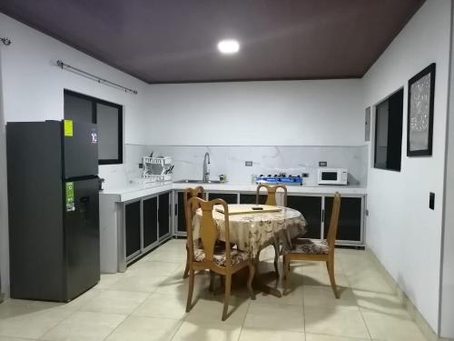 格雷西亚Mirada al Cerro, Apartamento completo的厨房配有桌椅和冰箱。