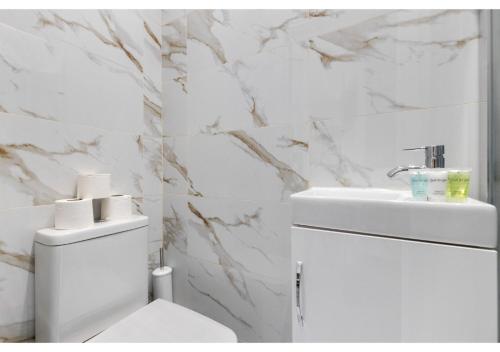 伦敦Brand New Homey and Stylish Perfect for Travellers的白色的浴室设有卫生间和水槽。