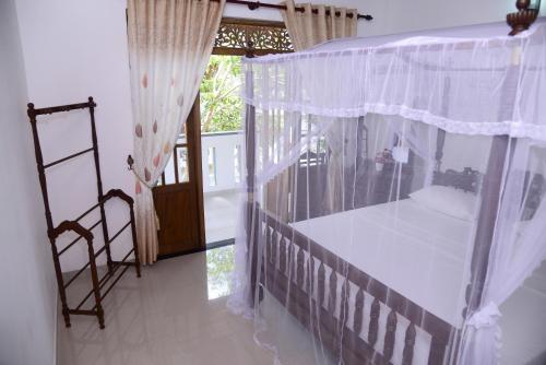 本托塔阿玉旅馆的一间卧室设有天蓬床和窗户。