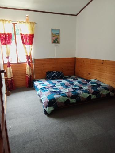 兰特包Hostel Papa Tia的一间卧室设有一张床和两个窗户。