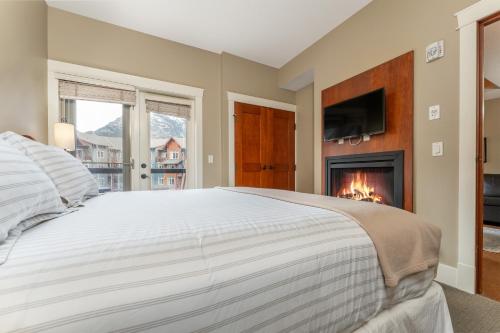 坎莫尔Solara Suite with Indoor Pool - Hot tub -Parking - GYM的一间卧室配有一张床和一个壁炉