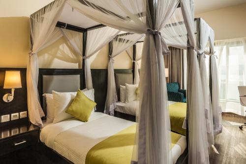 基苏木相思精品酒店 的一间卧室配有两张带窗帘的床