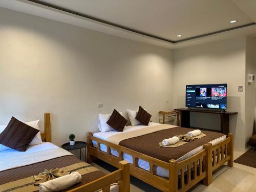 奈扬海滩桑塔里之家旅馆的一间卧室配有两张床和一台平面电视