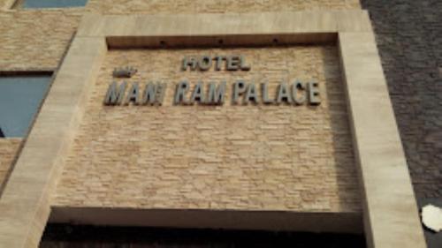 阿格拉Hotel Mani Ram Palace Agra的一座钟楼,上面有酒店宫殿的字样