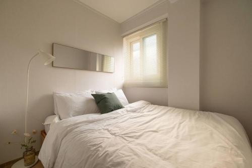 首尔Sodam Stay的卧室配有一张白色床,墙上配有电视