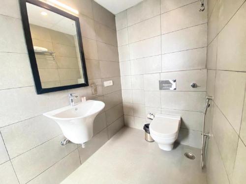 新德里Hotel Orchid INN at Budget Bazaar Janakpuri的白色的浴室设有水槽和卫生间。