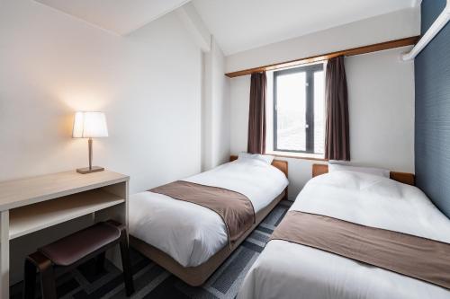 宫津市天桥立酒店的酒店客房配有两张床和一张书桌