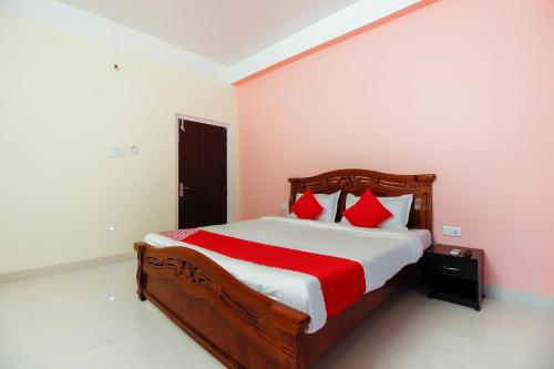 DispurAditya Guest House的一间卧室配有一张带红色枕头的大床