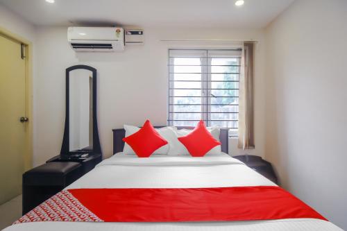 钦奈Pride Hospitality Nungambakkam的一间卧室配有一张带红色枕头的大床