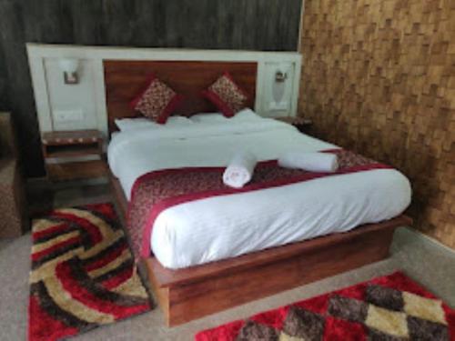 巴德里纳特Hotel Badrinath Anant Badrinath的一间卧室配有带白色床单和枕头的床。