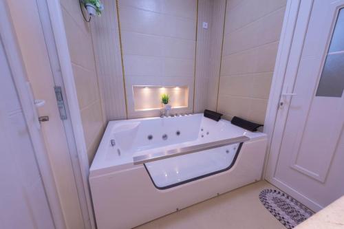 Ḩayl Yamanبهجة الجبل الأخضر的白色的浴室设有浴缸和水槽。