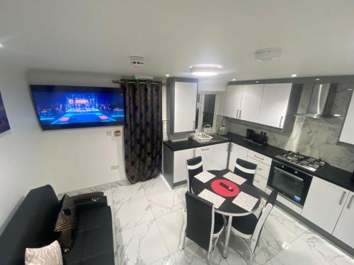 海斯THE ROYAL BOUTIQUE OXFORD LODGE by LONDON SLEEP 8的厨房配有桌椅,墙上配有电视。
