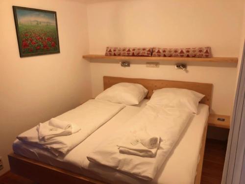 索内纳尔佩·纳斯费尔德Beautiful chalet apartment - ski-in & ski-out的配有2个白色枕头的客房内的一张床位