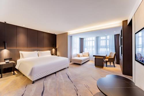 巴彦淖尔巴彦淖尔华美达酒店的配有一张床和一张书桌的酒店客房