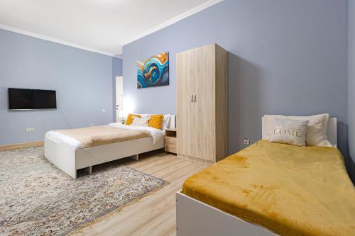 阿斯塔纳Апартаменты Expo Residents со всеми удобствами的一间带两张床和电视的小卧室