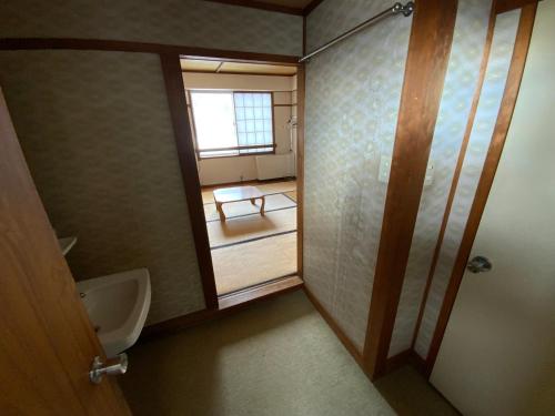 藏王温泉ロッヂ　スガノ的一间带小便器和盥洗盆的浴室以及窗户。