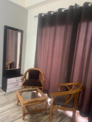 大诺伊达Paramount studio near pari chowk的一间设有两把椅子、一张桌子和一面镜子的房间