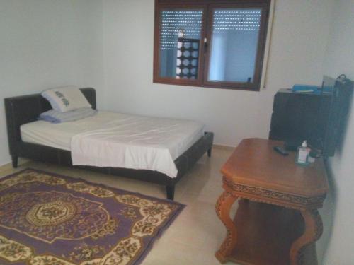 Villa Alhucemas的一间小卧室,配有一张床和一张桌子