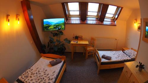 弗塞廷HOTEL BRITANNIA VSETÍN的客房设有两张床、一张桌子和一扇窗户。