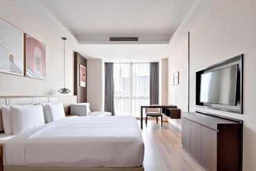 重庆重庆MontClassic精选酒店的配有一张床和一台平面电视的酒店客房