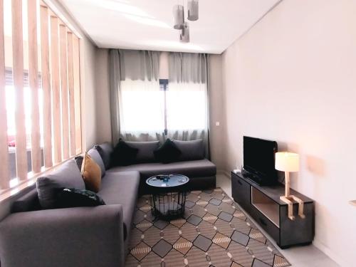 DerrouaBeautiful apartment next to airport Mohamed V的带沙发和电视的客厅