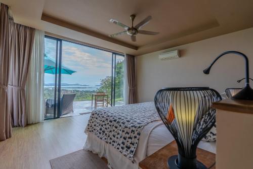 珍南海滩White Monkey Villa - Private Pool & Jacuzzi的一间卧室设有一张床和一个大型玻璃窗