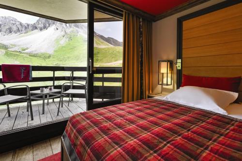蒂涅Belambra Clubs Tignes Val Claret的一间卧室设有一张床和一个美景阳台