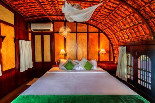 阿勒皮Spice Coast Cruises - Houseboat的一间卧室设有一张带木制天花板的大床