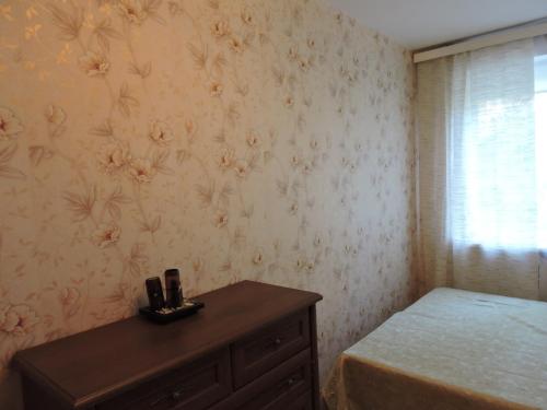 纳尔瓦约埃苏Karja 5 Apartment的一间卧室配有一张床、一个梳妆台和一扇窗户。