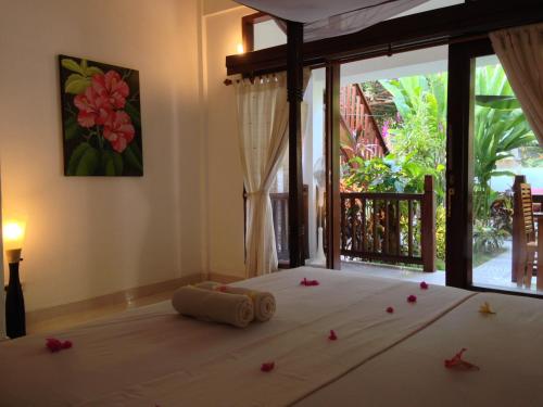 吉利特拉旺安鲁玛卡哈亚旅馆的卧室配有一张带鲜花的床,位于地板上